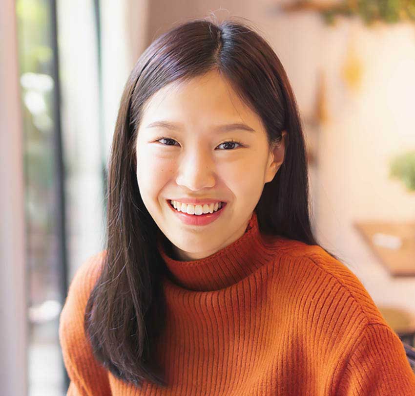 Smiling young woman in an orange sweater