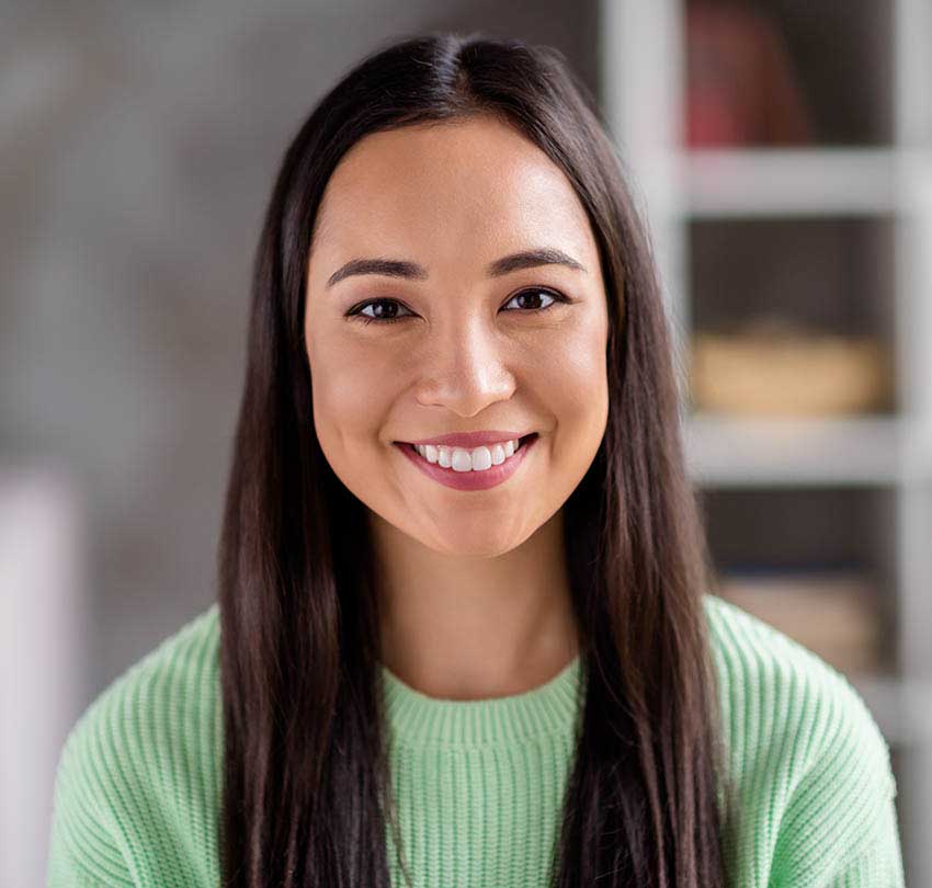 Smiling woman with long dark hair in a green sweater